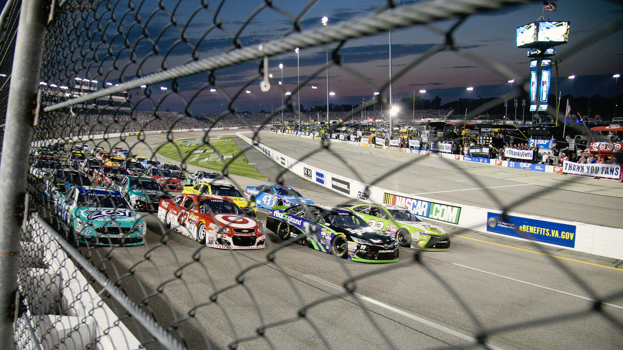 A tight pack of cars race on the Richmond International Raceway at a qualifying event