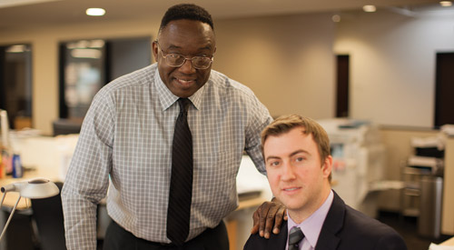 Picture Of Two Men In An Office Smiling